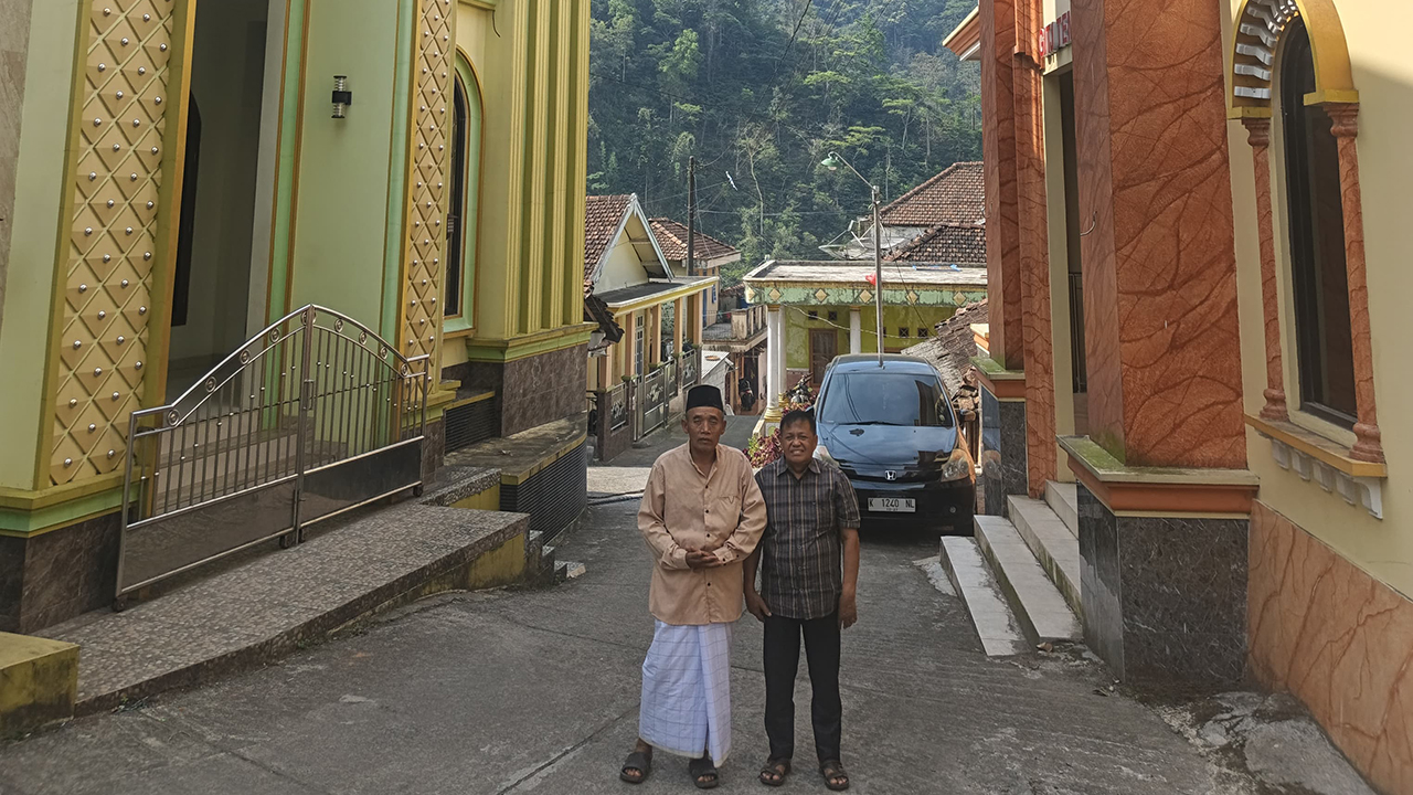 Abu Abdillah, imam of the Nurul Hikmah Mosque, and Suwadi, a leader of the GITJ Tempur Church, stand in the narrow lane that separates the mosque and the church in Tempur, Indonesia. — Danang Kristiawan
