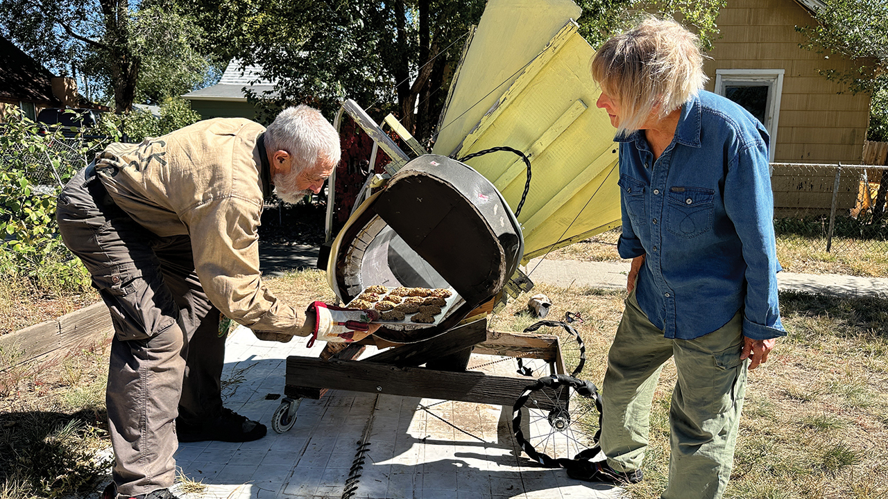 Peter Sprunger-Froese removes cookies from the solar oven he and his wife, Mary, share with their neighbors in Colorado Springs. — Donna Johnson