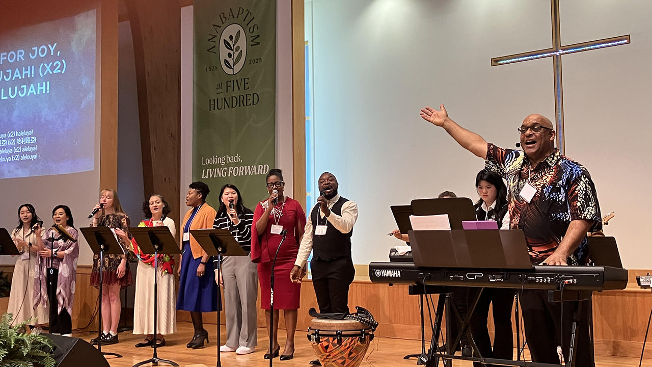Makinto, right, of Faith Chapel in Los Angeles, and singers from other Mosaic congregations lead worship at the Mosaic Mennonite Conference assembly Nov. 1 at Souderton Mennonite Church in Pennsylvania. Everyone was invited to sing in Indonesian, Spanish and English. — Paul Schrag/AW