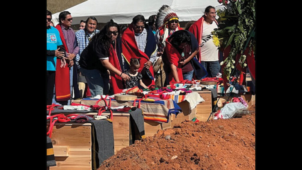 The remains of 16 children of the Cheyenne and Arapaho Tribes were laid in their final resting place in Concho, Okla., on Oct. 5. Chief Gordon Yellowman, in headdress, prayed over the children. — Susan Hart