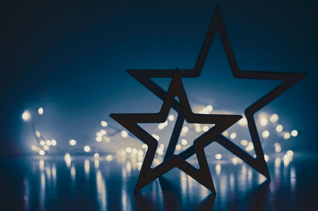 black-rimmed five-point stars against a blue background with white lights