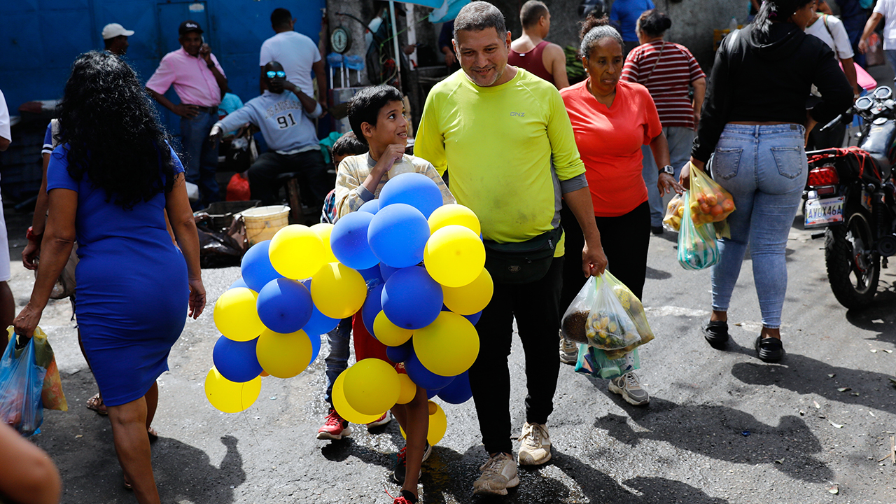 Shopper stroll along a market Jan. 7 in the Petare neighborhood of Caracas, Venezuela. — Cristian Hernandez/AP