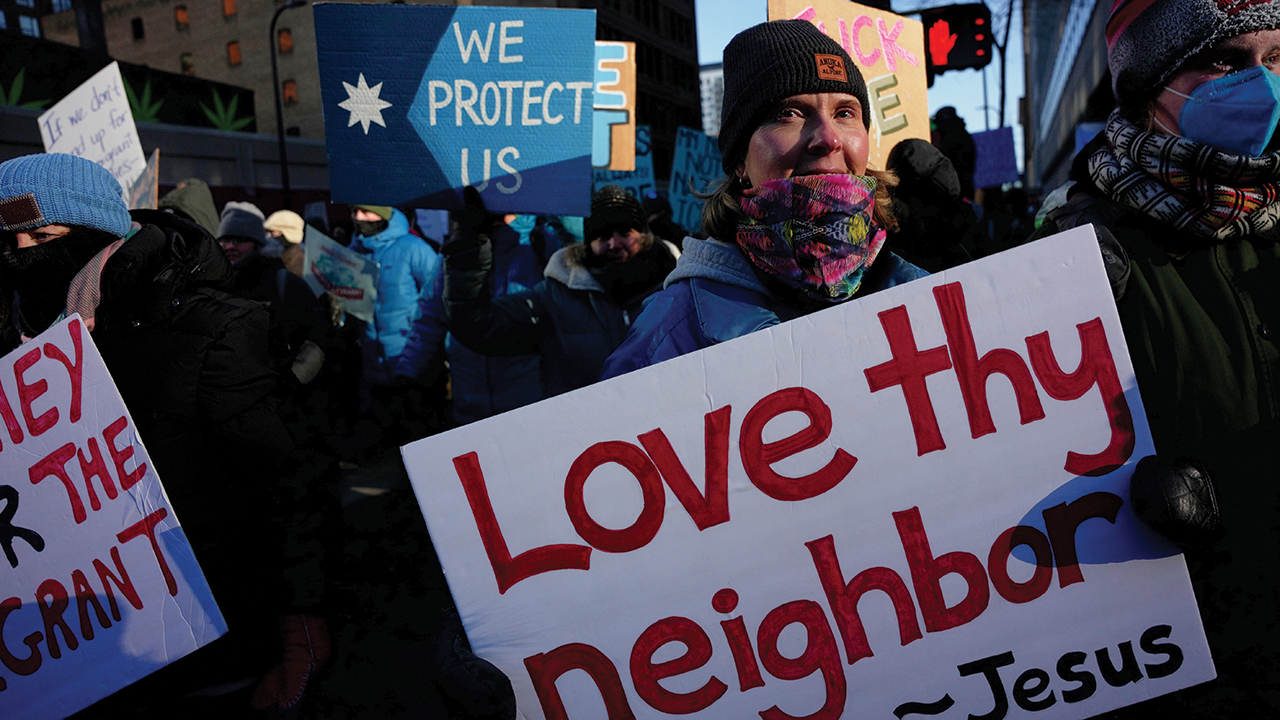 A protester holds a sign reading “Love thy neighbor — Jesus” during a rally against federal immigration enforcement Jan. 23 in Minneapolis. — Angelina Katsanis/AP