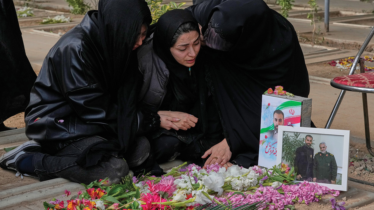 Relatives of a man who was killed in a U.S.-Israeli strike mourn at his grave at Behesht-e Zahra cemetery in Tehran, Iran, March 9. — Vahid Salemi/AP