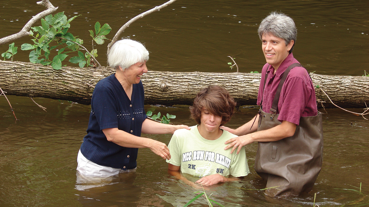 In 2009, Douglas Day Kaufman and co­pastor Brenda Meyer baptize Noah Kaufman, Douglas’ son, in the Elkhart River. — Courtesy of Douglas Day Kaufman