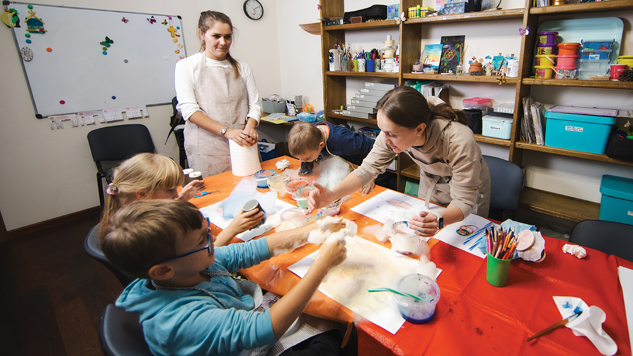 Children participate in an art therapy session at New Hope Center, an MCC partner in Zaporizhzhia, Ukraine, trying out bubble painting with child psychologist Kateryna. — New Hope Center