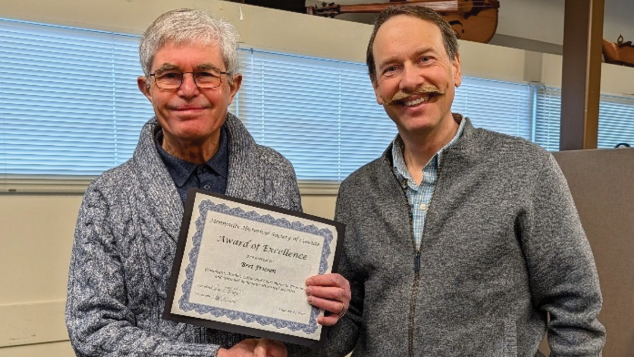 Bert Friesen, left, receives the Mennonite Historical Society of Canada’s Award of Excellence in January from MHSC President Conrad Stoesz. — MHSC