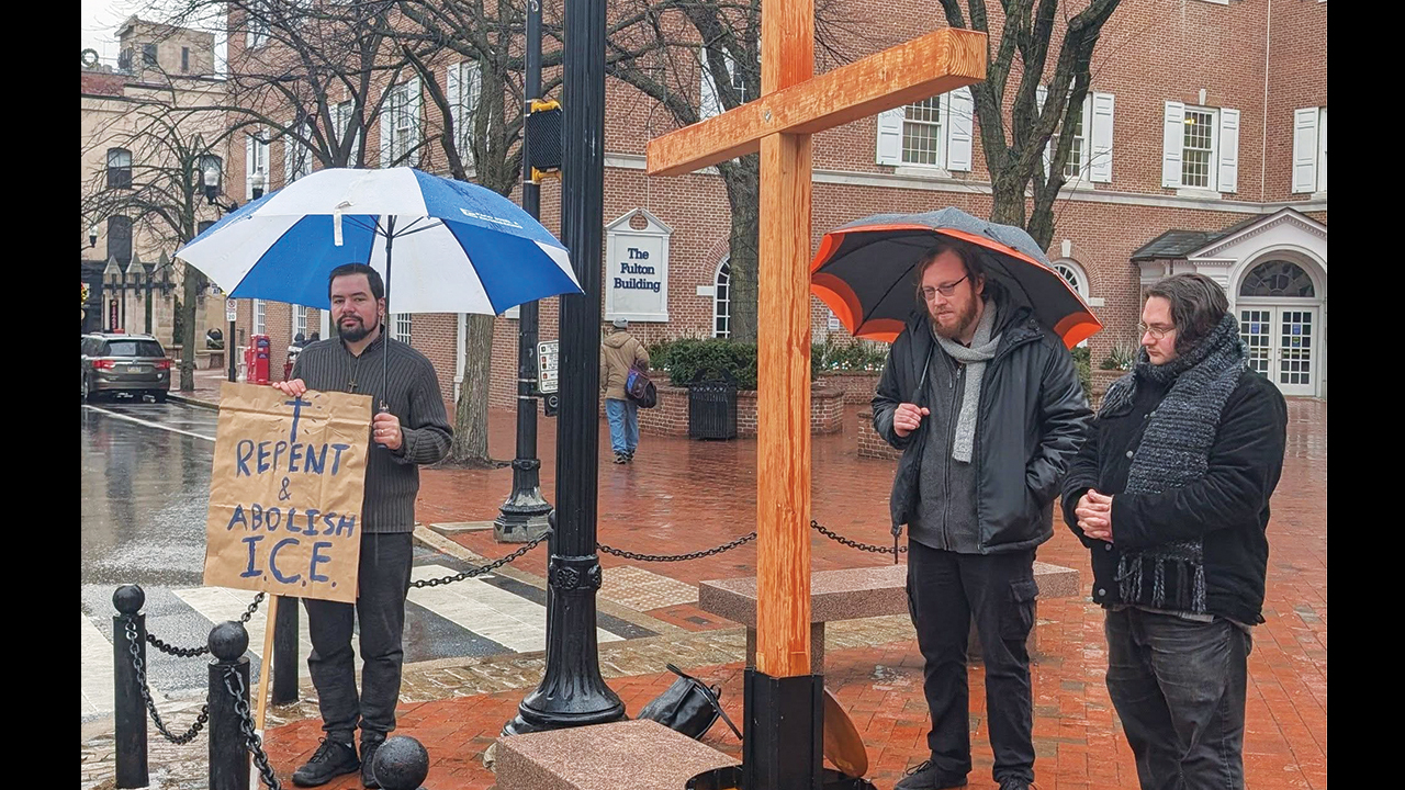 James Boll, right, prays Jan. 10 during a protest of Immigration and Customs Enforcement in Lancaster, Pa., with Sean Domencic, left, and Thomas Troop. — Jen Donovan