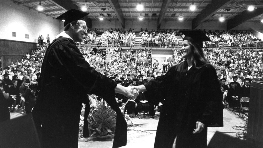 Edmund Janzen congratulates Harriet Huggins at Fresno Pacific College's 1985 commencement ceremony. — Fresno Pacific University