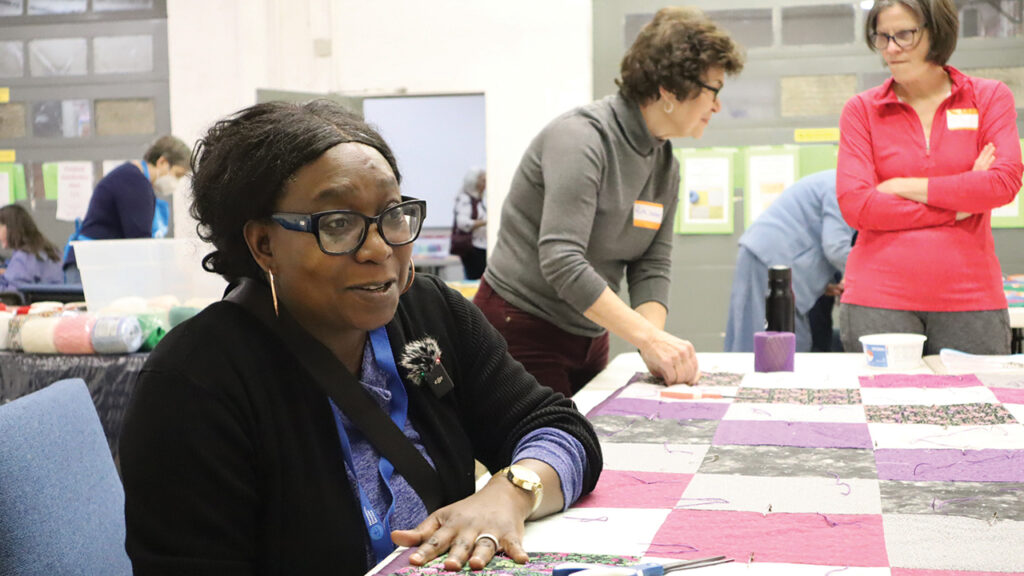 Fellistus Munakombwe talks about her motiva­tion for knotting comforters. — Laura Pauls Thomas/MCC