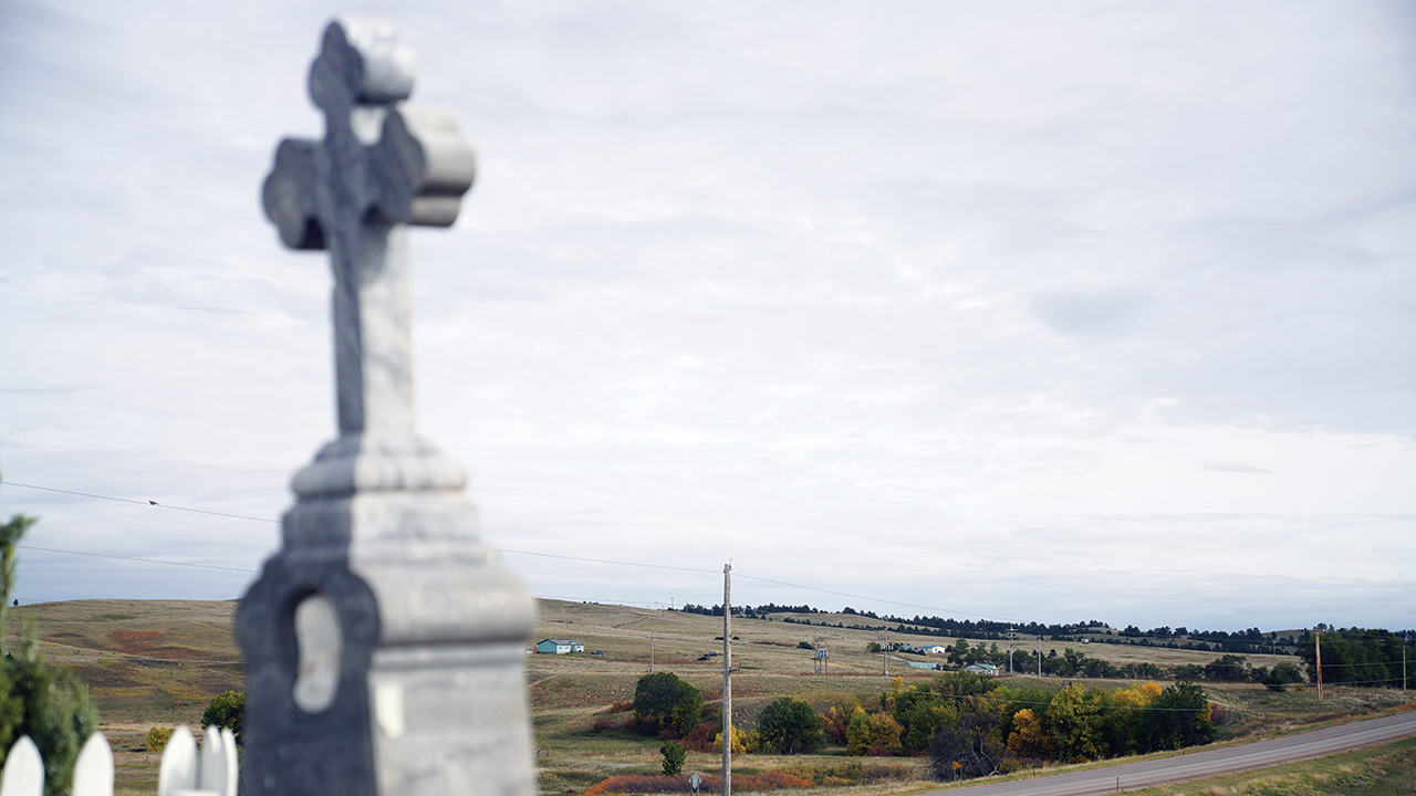 Pine Ridge Indian Reservation is seen from the burial place of Chief Red Cloud in Pine Ridge, S.D., in 2021. Red Cloud defended against U.S. land grabs as long as he could but converted to Catholicism and invited the Jesuits to start Holy Rosary Mission after he and his people were confined to Pine Ridge. — Emily Leshner/AP
