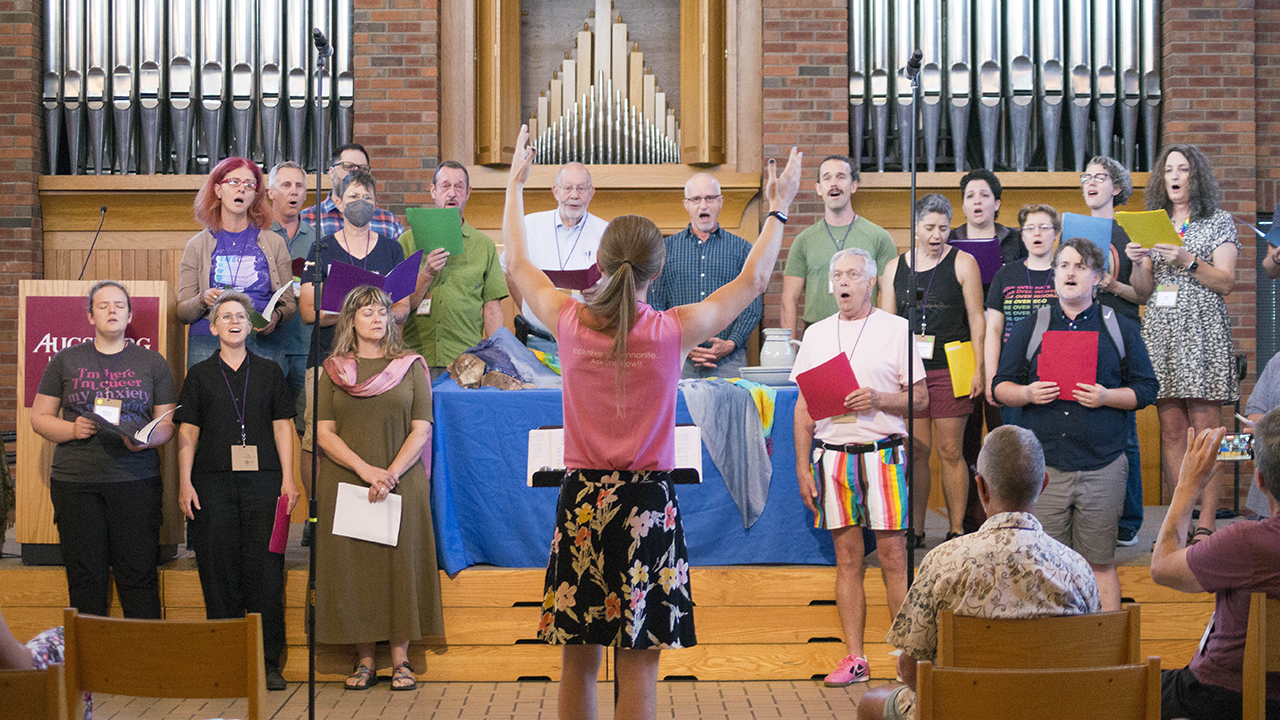 Pax Ressler of Philadelphia directs the choir during the 50th anniversary celebration of the Brethren Mennonite Council for LGBT Interests on May 30 in Augsburg Chapel at Augsburg University in Minneapolis. — Hannah Kraenbring/BMC