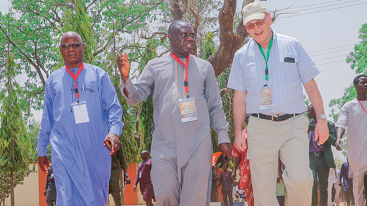 In Nigeria in March, Church of the Brethren moderator Don Fitzkee, right, walks with Daniel Y.C. Mbaya, center, president of the Church of the Brethren in Nigeria (Ekklesiyar Yan’uwa a Nigeria, or EYN) and EYN vice president Nuhu Mutah Abba. — EYN News