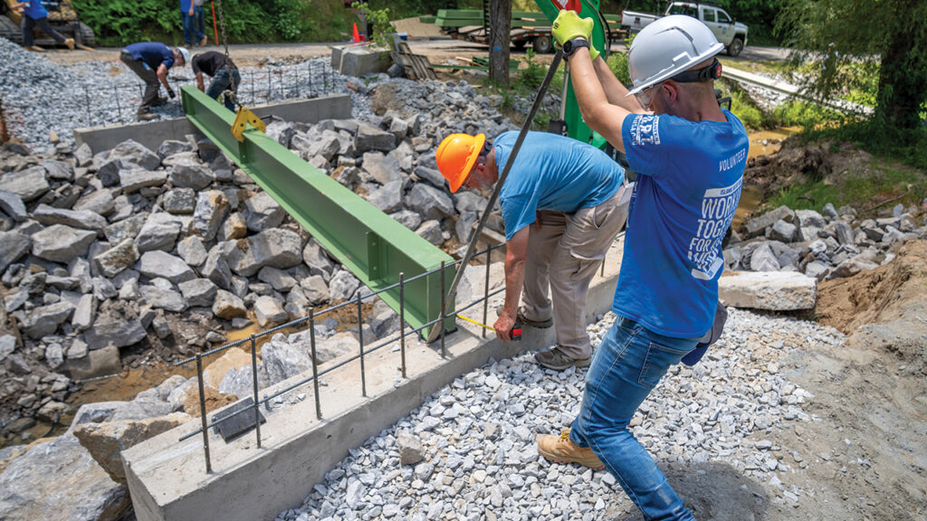 Abdullah Shawky, right, senior national disaster management specialist with Islamic Relief USA, works on a bridge with Mennonite Disaster Service and Islamic Relief USA volunteers on June 5 in Hendersonville, N.C. — Julie Kauffman/MDS