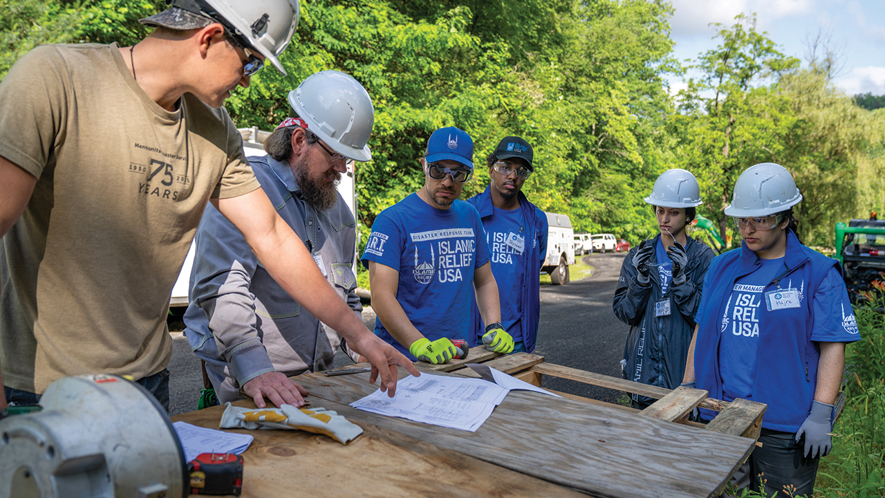Mennonite Disaster Service volunteers Christopher Blough and Jerry Yoder work with Islamic Relief USA personnel Abdullah Shawky, Tayseer Abubaker, Aliya Jabri and Hajra Qazi on June 1 in Hendersonville, N.C. — Paul Hunt/MDS