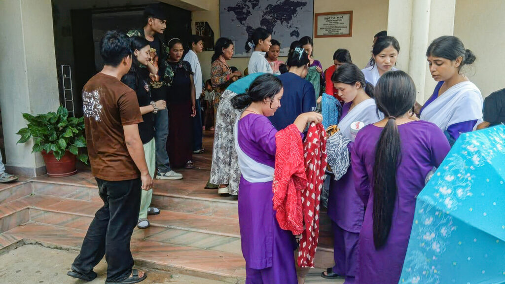 Families receive emergency relief items at a local church in the Nuwakot district of Nepal, where they are sheltering after the Aug. 26 flash floods. MCC partner SAHAS will provide food, hygiene items, water purification tablets, dignity kits, bedding and other essential items to 1,000 flood-affected people in evacuation centers. — Hirajeet Sunuwar
