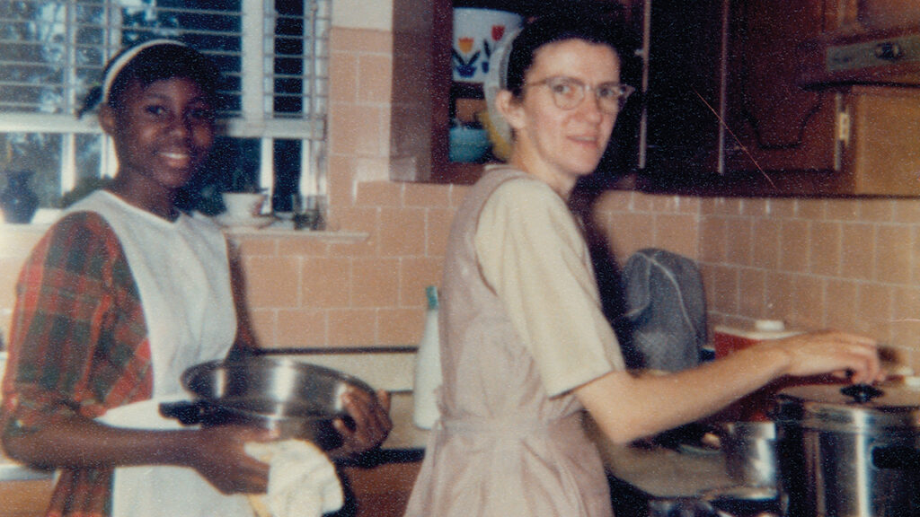 Fannie Lapp, right, cooks with neighborhood friend Cindy Sharpe, who was baptized into the Amish-Mennonite church and began to wear a covering and conservative-style dresses. — Courtesy of Joe Lapp