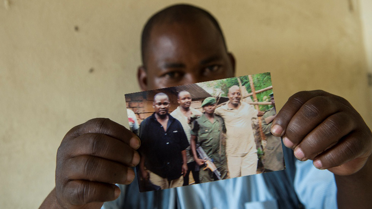 Emmanuel Billay Mussamba, former supervisor with the Program for Peace and Reconciliation, holds a photo from a visit with members of the Democratic Forces for the Liberation of Rwanda in eastern Congo. — Matthew Lester/MCC